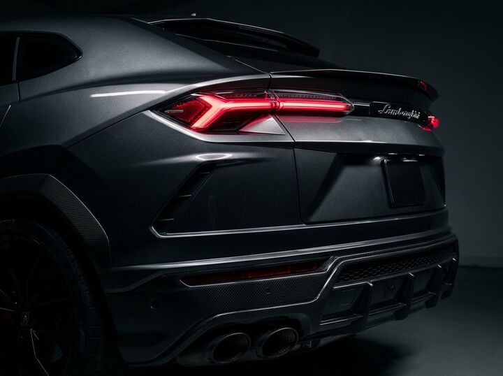 Traseira de um Lamborghini Urus grafite com as lanternas acesas