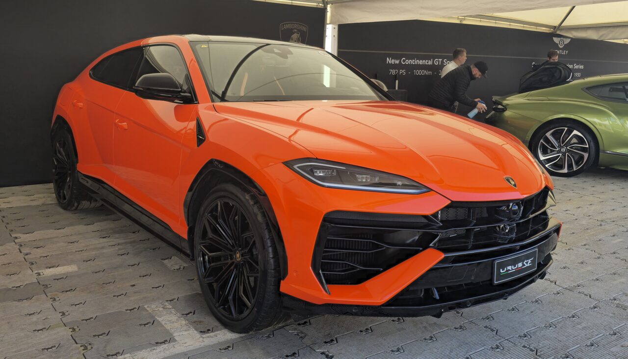 Lamborghini Urus SE laranja visto de frente num evento ao ar livre